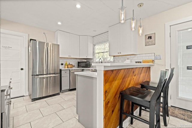 371 Sprucewood Ln, San Antonio, TX 78216 - kitchen featuring backsplash, a peninsula, appliances with stainless steel finishes, and light countertops