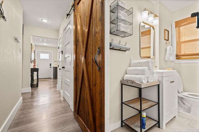 371 Sprucewood Ln, San Antonio, TX 78216 - corridor featuring light wood finished floors, baseboards, and a barn door