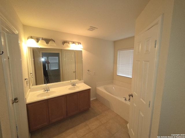 full bathroom with double vanity, a garden tub, tile patterned flooring, and a sink