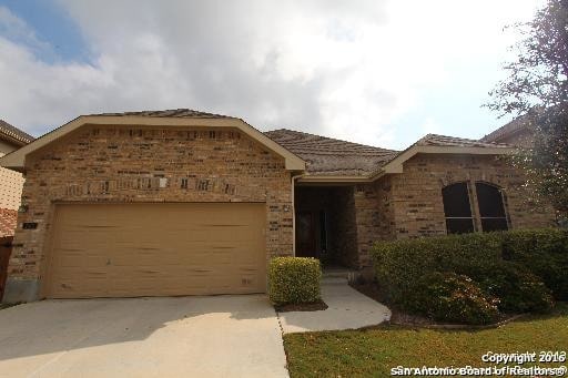 single story home featuring an attached garage, brick siding, and concrete driveway