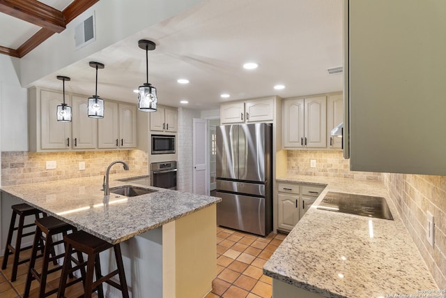 kitchen with visible vents, a sink, decorative backsplash, a peninsula, and appliances with stainless steel finishes