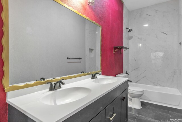 bathroom featuring double vanity, toilet, and bathing tub / shower combination