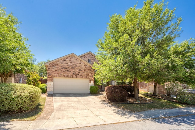 obstructed view of property featuring concrete driveway, brick siding, and a garage