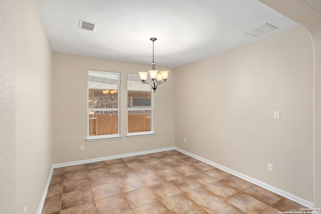 spare room featuring a chandelier, visible vents, and baseboards