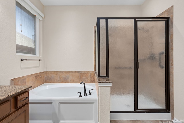 bathroom with a garden tub, vanity, and a stall shower