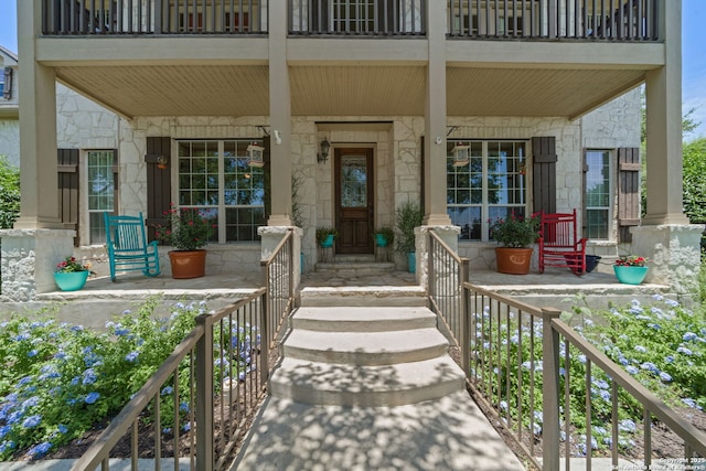 3329 Navasota Cir, San Antonio, TX 78259 - doorway to property with stone siding, covered porch, and a balcony