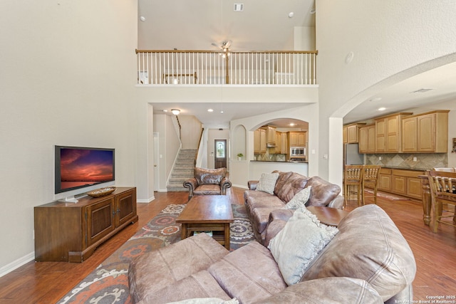 3329 Navasota Cir, San Antonio, TX 78259 - living room with light wood-style flooring, stairs, arched walkways, and a high ceiling