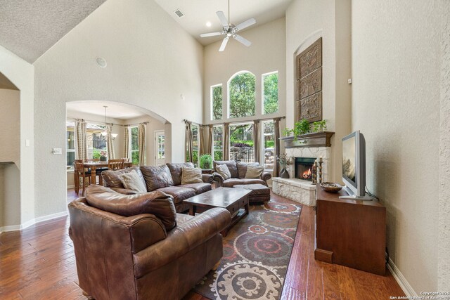 3329 Navasota Cir, San Antonio, TX 78259 - living area with hardwood / wood-style flooring, arched walkways, a stone fireplace, ceiling fan, and high vaulted ceiling