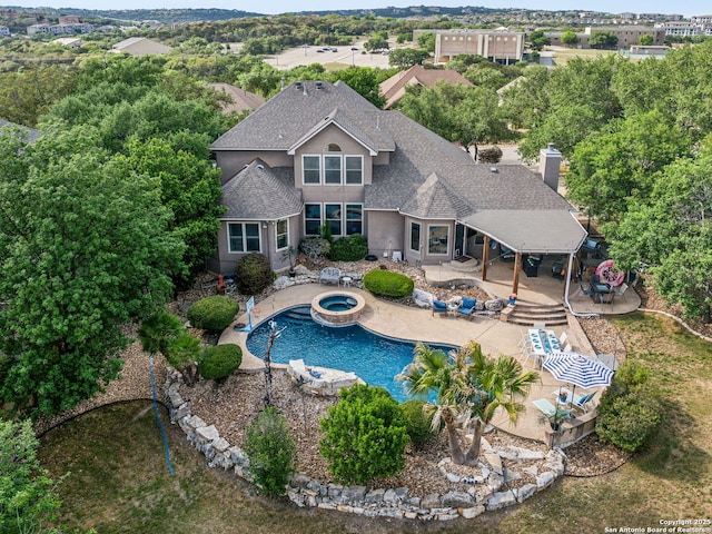 outdoor pool featuring a patio area and an in ground hot tub