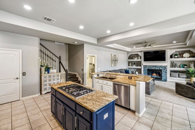 kitchen with open floor plan, visible vents, an island with sink, and appliances with stainless steel finishes