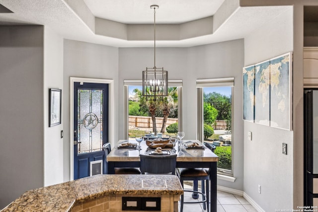 dining room featuring an inviting chandelier, a healthy amount of sunlight, baseboards, and light tile patterned floors