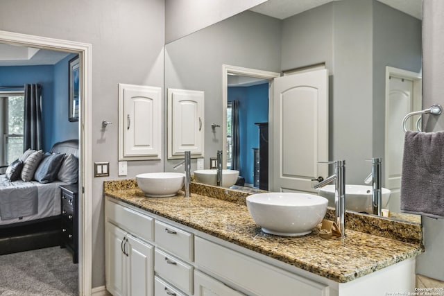bathroom featuring connected bathroom, a sink, and double vanity