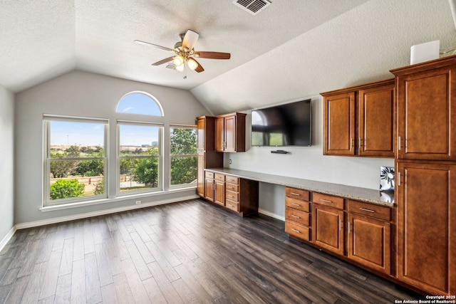 kitchen featuring visible vents, a ceiling fan, built in study area, and vaulted ceiling