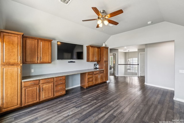 kitchen with brown cabinetry, lofted ceiling, a ceiling fan, and dark wood-style flooring