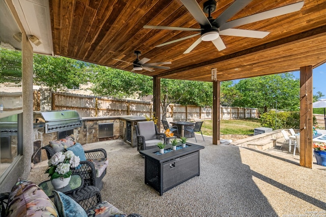 view of patio featuring outdoor dining space, a fenced backyard, a grill, an outdoor kitchen, and ceiling fan