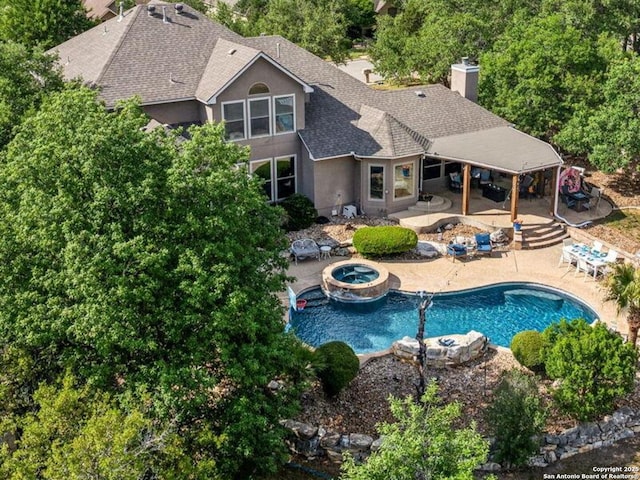 view of pool featuring a patio area, a fire pit, and a pool with connected hot tub