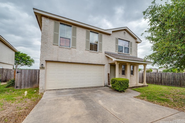 traditional home with a garage, driveway, brick siding, and fence
