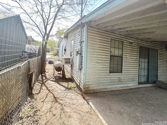 view of property exterior featuring fence and a patio area