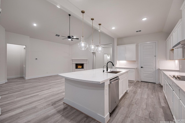 kitchen with visible vents, stainless steel dishwasher, a sink, a lit fireplace, and ceiling fan