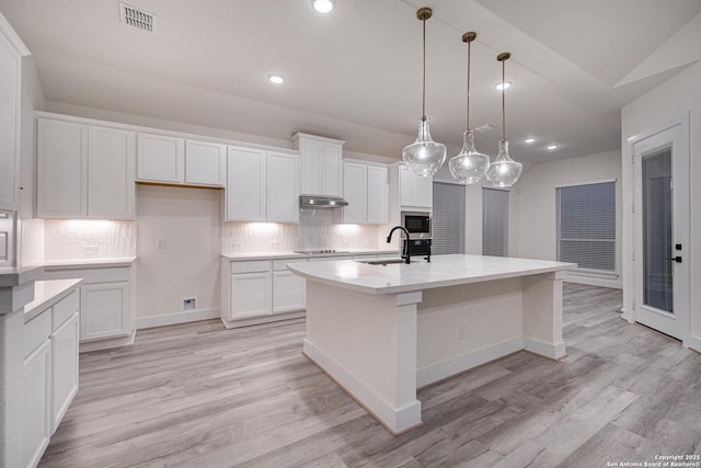 kitchen featuring white cabinetry, under cabinet range hood, visible vents, and recessed lighting