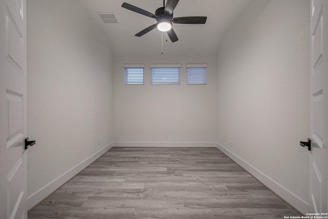 spare room featuring light wood-type flooring, baseboards, a ceiling fan, and visible vents
