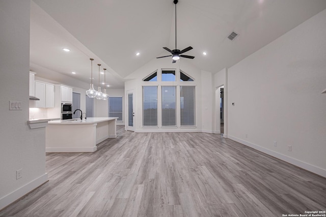 living area featuring light wood finished floors, baseboards, a ceiling fan, and visible vents