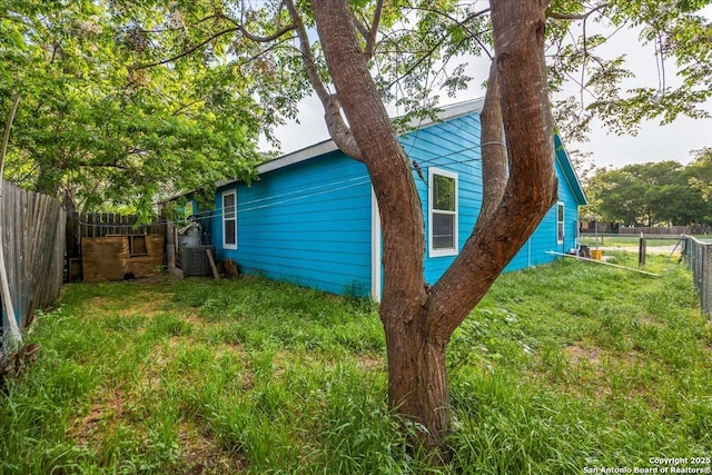 610 Novella, Adkins, TX 78101 - view of side of home featuring a fenced backyard, central AC unit, and a yard