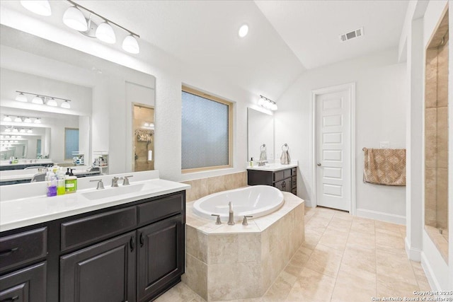 full bath with a sink, a tile shower, visible vents, lofted ceiling, and a garden tub