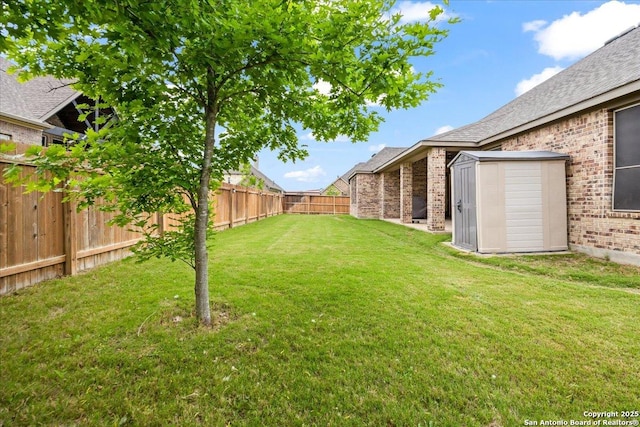 view of yard with an outdoor structure, a storage unit, and a fenced backyard