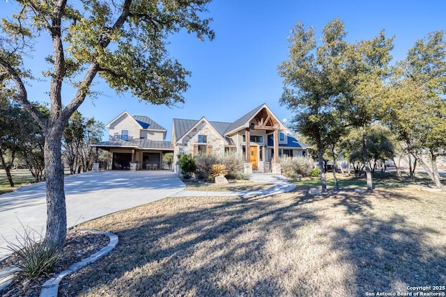 view of front of property featuring an attached garage, a standing seam roof, concrete driveway, and metal roof