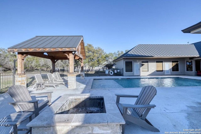 community pool featuring a gazebo, a patio area, an outdoor fire pit, and fence