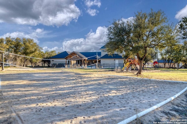 exterior space featuring fence, playground community, and volleyball court