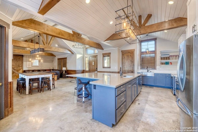 kitchen featuring concrete flooring, lofted ceiling with beams, stainless steel appliances, and a sink