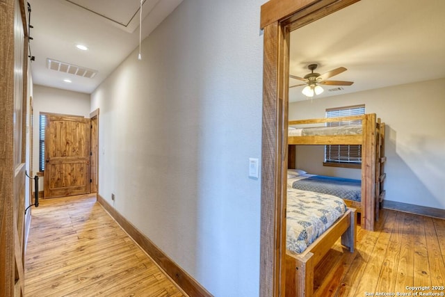 hallway featuring hardwood / wood-style floors, baseboards, and visible vents