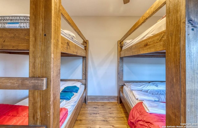 bedroom featuring baseboards and wood finished floors