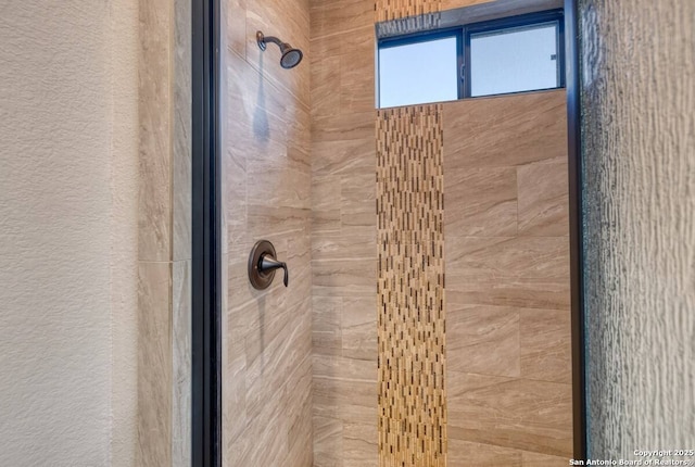 full bathroom featuring a textured wall and a stall shower