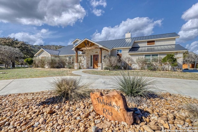 67 Stepping Stone, Concan, TX 78838 - view of front of house with stone siding, a standing seam roof, and metal roof