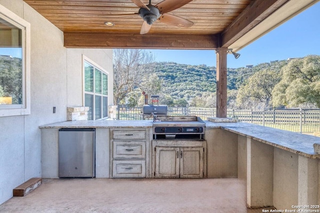 67 Stepping Stone, Concan, TX 78838 - view of patio / terrace featuring grilling area, fence, exterior kitchen, and a mountain view