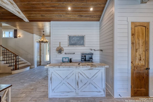 67 Stepping Stone, Concan, TX 78838 - living area featuring stairway, wood finished floors, a chandelier, wooden ceiling, and wood walls