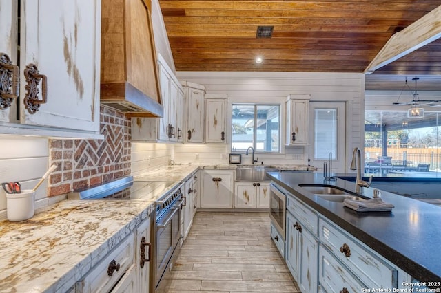 67 Stepping Stone, Concan, TX 78838 - kitchen featuring light wood finished floors, a sink, wood ceiling, appliances with stainless steel finishes, and premium range hood