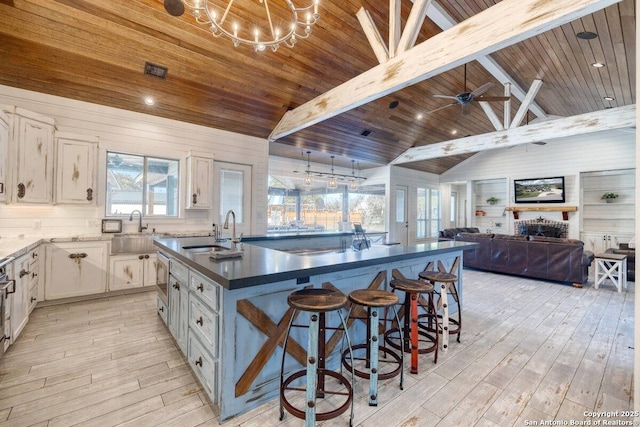 67 Stepping Stone, Concan, TX 78838 - kitchen featuring vaulted ceiling with beams, wooden ceiling, a sink, and light wood-style floors