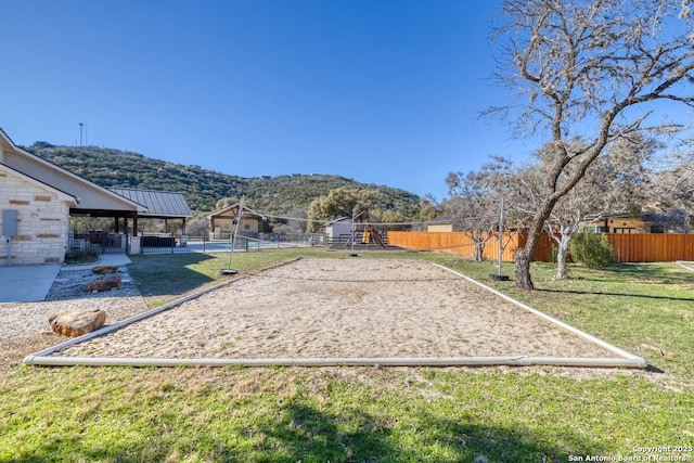 67 Stepping Stone, Concan, TX 78838 - view of yard featuring volleyball court, a mountain view, fence, and a playground