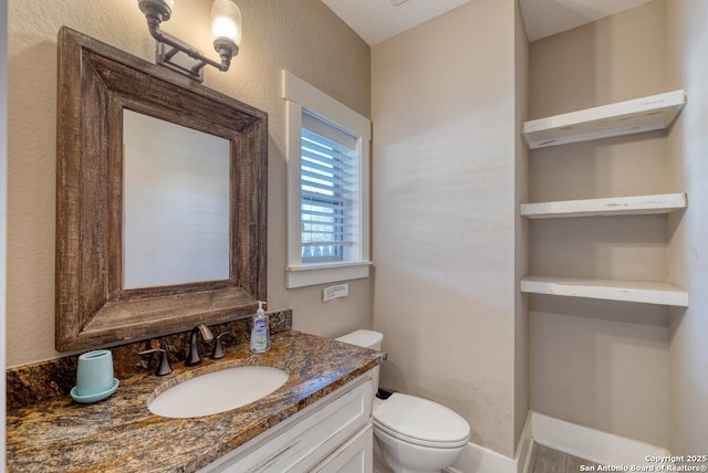 67 Stepping Stone, Concan, TX 78838 - half bathroom featuring toilet, a textured wall, and vanity