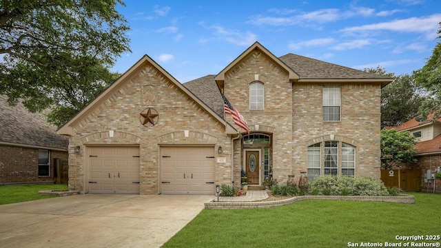 view of front facade featuring an attached garage, brick siding, a front yard, and concrete driveway