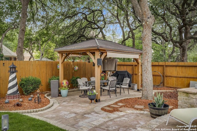 view of patio with a fenced backyard, outdoor dining space, and a gazebo