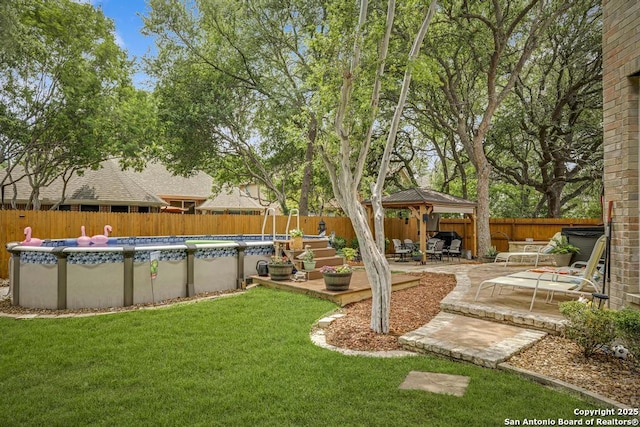view of yard featuring a patio, a gazebo, a fenced in pool, and a fenced backyard