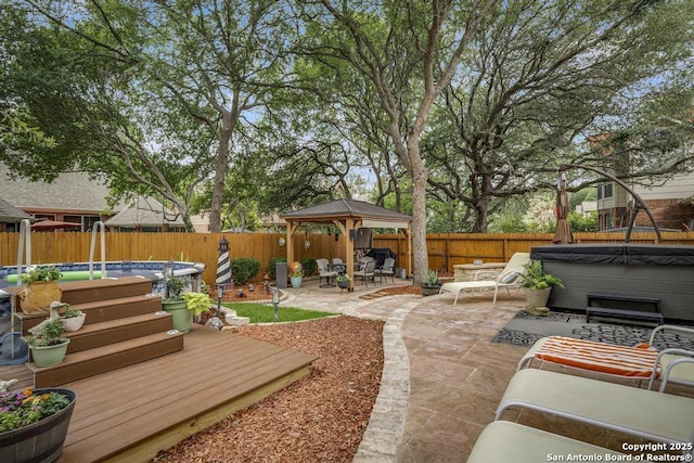 view of yard featuring a hot tub, a gazebo, a fenced backyard, and a pool