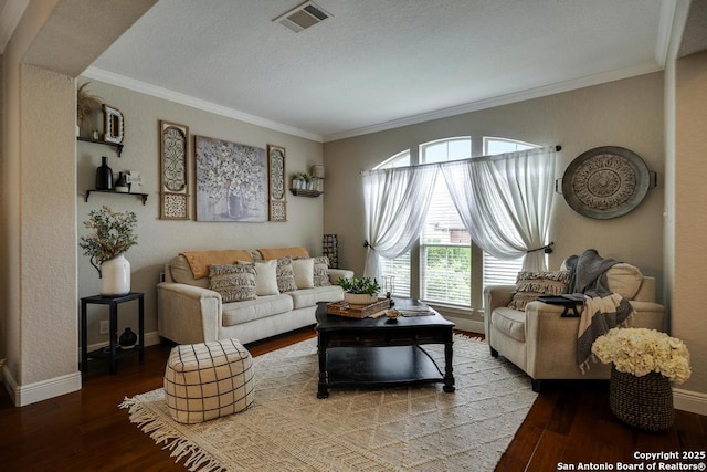 living room featuring crown molding, baseboards, visible vents, and wood finished floors
