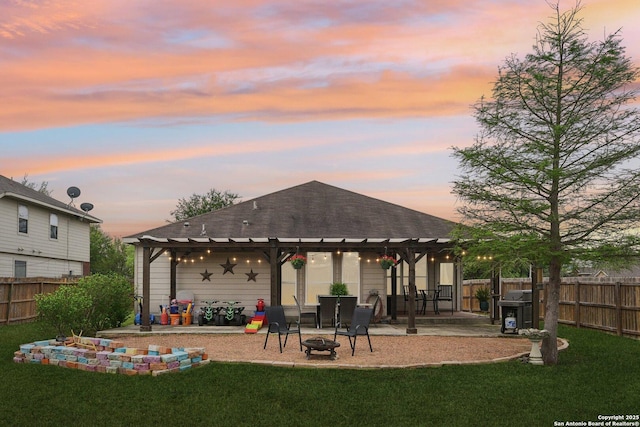 back of house at dusk with a pergola, an outdoor fire pit, and a yard