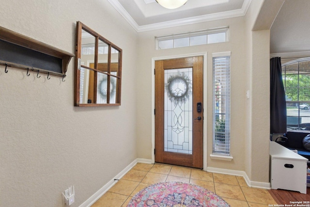 entrance foyer with baseboards, crown molding, a textured wall, and light tile patterned floors